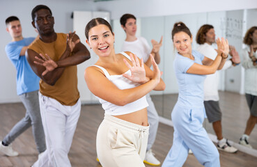 Group of international people dancing in gym with crossed hands. The concept of sport, dance and...