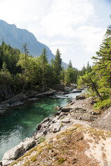 river surrounded by rocks and trees with mountain and sky in background