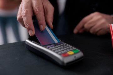 Elderly client putting credit card on pos terminal paying for pharmaceutics treatment in pharmacy, buying vitamins, supplements to help cure disease. Health care support service. Close up