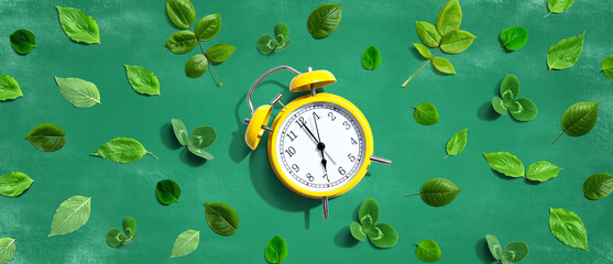 Yellow vintage alarm clock with green leaves