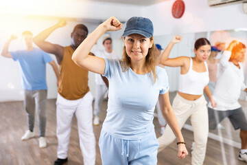 Fototapeta premium Group of active women and men practicing energetic dance in a modern dance studio