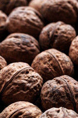 Ripe, whole walnuts in a wrapper. Vertical orientation.