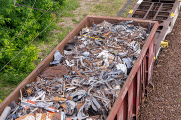 Above view of railway cargo train wagon filled by old rusty black metal scrap garbage forfactory...