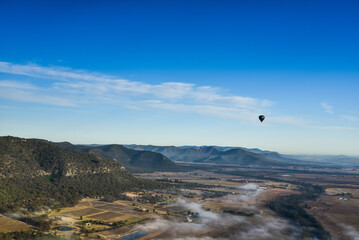 Enjoying travelling with hot air balloon in the clear blue sunrise morning sky for family gathering and school holiday travel destination