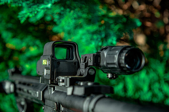 Modern automatic rifle. Weapons for police, special forces and the army. A carbine with optical sights on a green fir back.