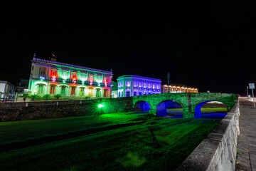 Fototapeta premium Sao Joao del Rei, Minas Gerais, Brazil. Bridge over river and old buildings of the city hall of the historic city at night