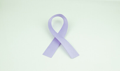 Purple ribbon as symbol of Cancer Awareness Month (World Cancer Day) over withe color background, copy space.