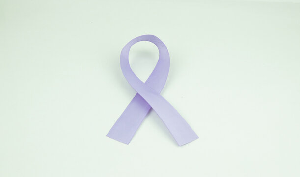 Purple ribbon as symbol of Cancer Awareness Month (World Cancer Day) over withe color background, copy space.