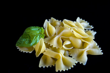 Macro of Farfalle Pasta with a Touch of Fresh Basil on Black Background
