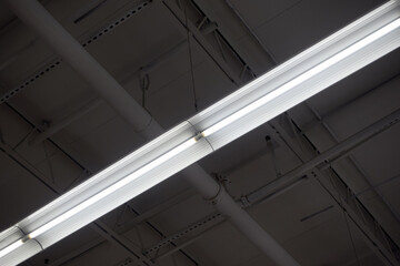Linear white LED or fluorescent ceiling strip light fixture inside a store