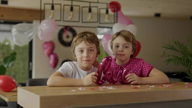 Boy and girl at the bar table in the decorated room for Valentine's Day