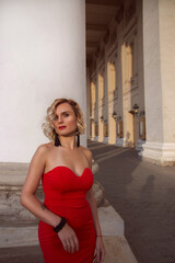 Naklejka premium Portraite woman in a sexy red dress walks in the center of Moscow.