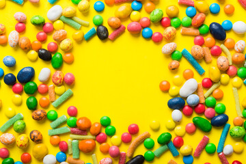 Mixed collection of colorful candy, on colored background. Flat lay, top view. frame of colorful chocolate coated candy