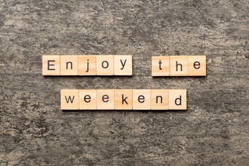 Enjoy the weekend word written on wood block. Enjoy the weekend text on cement table for your desing, Top view concept
