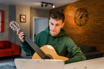 One man teenager learn to play guitar at home online lesson tutorial