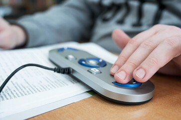 A visually impaired man uses a scanning and reading machine.
