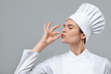 Female chef showing perfect sign on light grey background