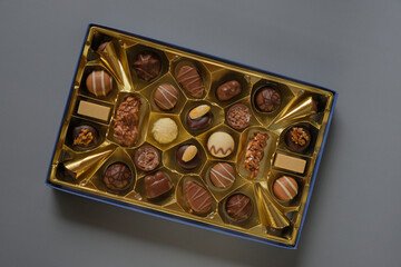 Milk chocolate candy.Sweets and desserts. Assorted chocolate candies in a box on a gray background. Chocolate box. Sweets box in assortment