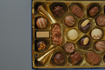  chocolate candies in a box on a gray background. Chocolate box. Milk chocolate candy.Sweets and desserts.Sweets box in assortment