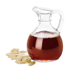 Fresh pumpkin seed oil in glass jug and kernels isolated on white