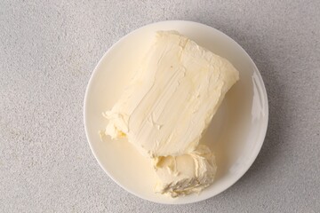 Plate with tasty homemade butter on white textured table, top view