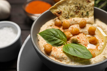 Delicious creamy hummus with chickpeas and chips on table, closeup