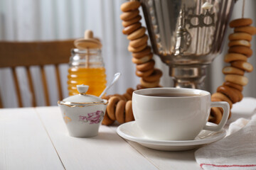 Composition with delicious ring shaped Sushki (dry bagels) and tea on white wooden table indoors, space for text