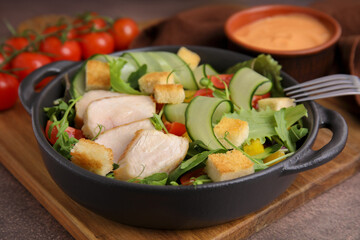 Delicious salad with croutons, chicken and vegetables served on grey table, closeup