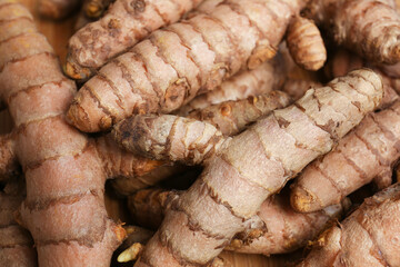 Many whole turmeric roots as background, closeup