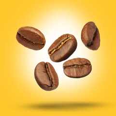 Many roasted coffee beans falling on yellow background