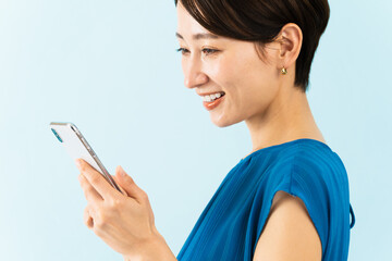 Fototapeta premium スマートフォンを使うワンピースを着た若い女性