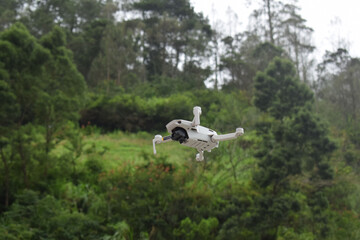 Fototapeta premium White drone quadcopter with digital camera and sensors flying in mountains