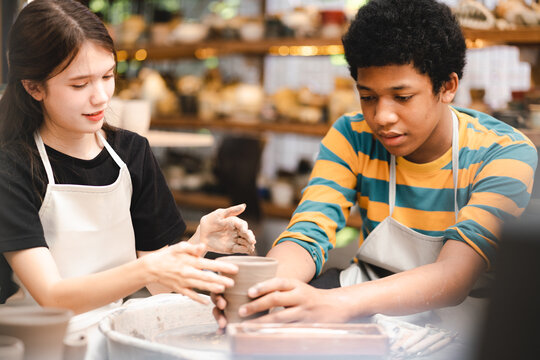 happy smiling girl having fun to learning and work with craft art of clay hand-made workshop in ceramic studio, little ceramist enjoy in creative handcraft hobby with pottery artisan school class