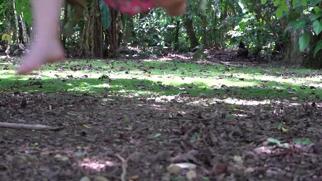 P&eacute;s de uma crian&ccedil;a balan&ccedil;ando num brinquedo de cordas ao ar livre.