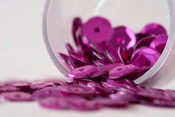 Obraz na płótnie Canvas Purple Sequins Spilled from a Jar