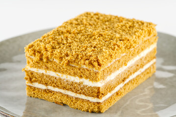 Homemade Honey cake. Honey cake Medovik, layer cake on white plate. Closeup view. sweet dessert cake. Slice of layered honey cake selective focus.