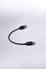 Black USB cable with plugs type A and type C isolated on a white background. Short cable