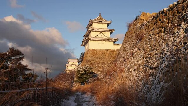 Walking movement toward Japanese castle in golden morning light