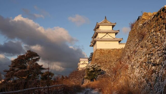 Historic Akashi Castle on ancient stone walls on snowy winter day