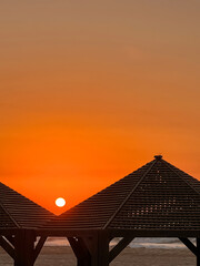 View of sea beach with gazebos at sunset