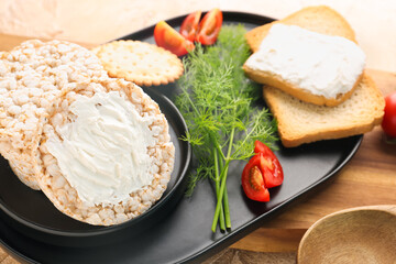 Plate of tasty crackers with cream cheese, dill and tomatoes on table, closeup