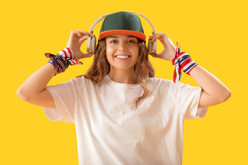 Female hip-hop dancer with headphones on yellow background