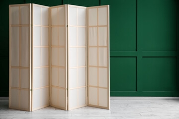 Beige folding screen near green wall