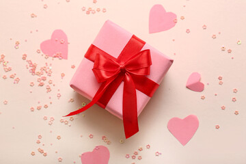 Composition with gift box, paper decor and sequins on color background. Valentine's Day celebration