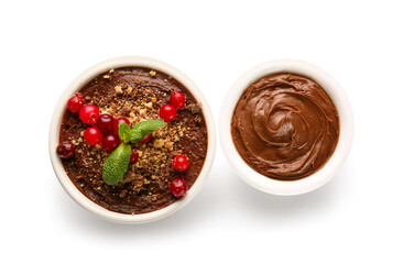 Bowls of delicious chocolate pudding with cranberry and mint isolated on white background