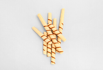 Tasty wafer rolls on grey background