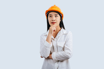 Young female engineer in helmet stand with thoughtful posture