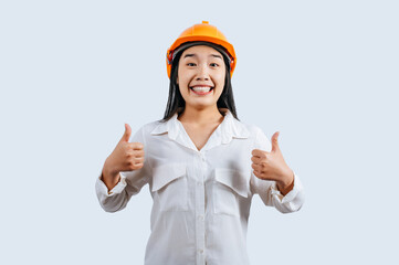 Young female engineer in helmet stand with thumb up posture