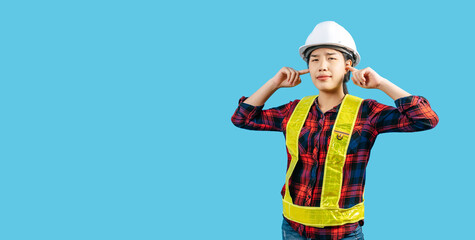 Young asian engineer female wearing helmet use finger plug her ears