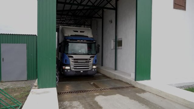 Huge transportation truck loaded with manufactured products. Transportation truck vehicle leaving the industrial production plant. Truck transporting the produced items from the warehouse.